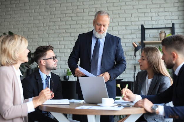 Gruppo di partner commerciali che discutono idee e pianificano il lavoro in ufficio.