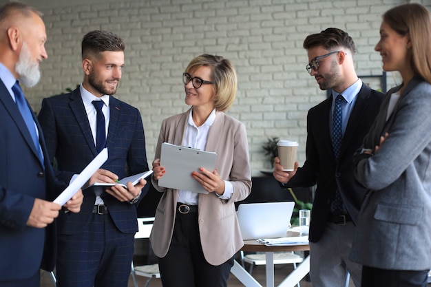 Gruppo di partner commerciali che discutono idee e pianificano il lavoro in ufficio.