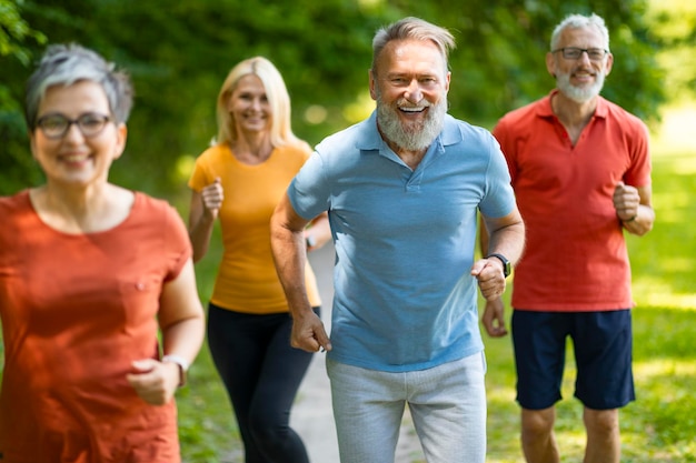 Gruppo di pensionati attivi di anziani sportivi che fanno jogging all'aperto