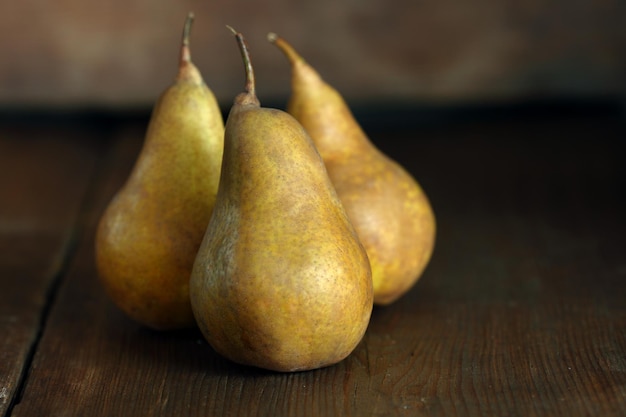 Gruppo di pere mature giacciono su vecchie tavole di legno piallate