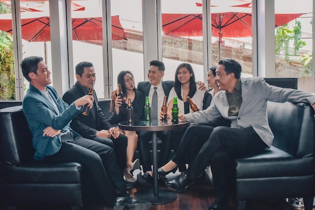 Gruppo di persone asiatiche che bevono nel gruppo di affari di congratulazioni alla festa Gruppo di amici che si godono un drink serale al bar