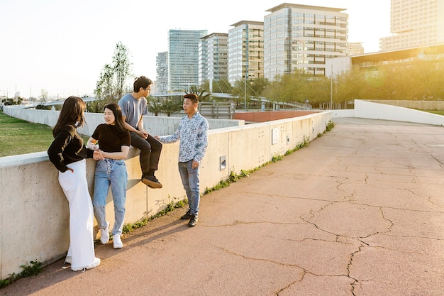 Gruppo di persone asiatiche provenienti da diversi paesi che parlano in strada al tramonto