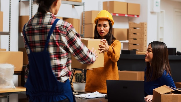 Gruppo di persone che controllano i prodotti nelle scatole per inviare merci per l'ordine del negozio al dettaglio. Impiegato asiatico che fa lavoro di squadra per la pianificazione finanziaria o la distribuzione, piccola impresa nel magazzino.