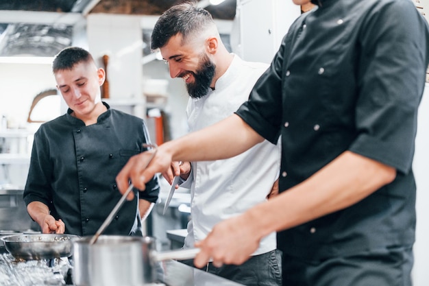 Gruppo di persone che cucinano insieme il cibo in cucina Giornata intensa al lavoro