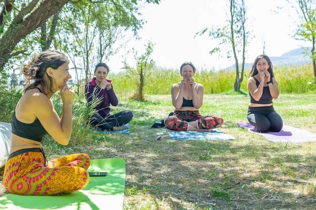 gruppo di persone che fanno esercizi di yoga nel parco donne che si rilassano nel parco