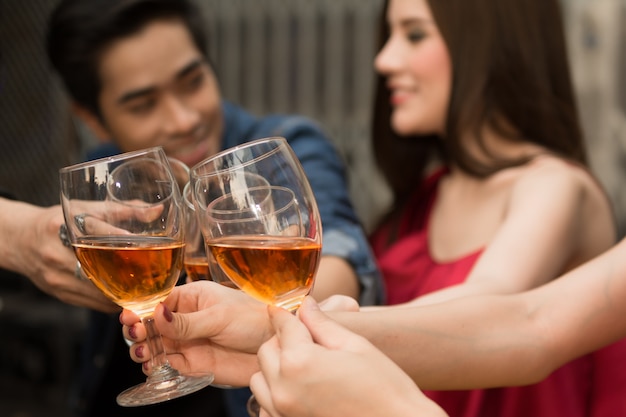 Gruppo di persone che fanno un brindisi insieme con godendo alla festa di notte.