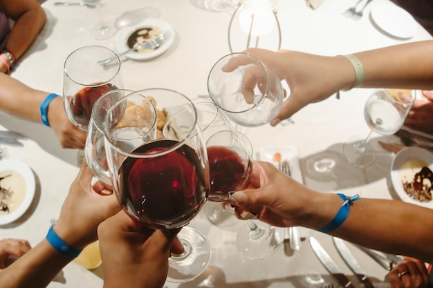 Gruppo di persone che tintinnano bicchieri di vino per festeggiare