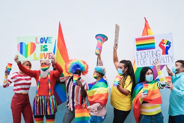 Gruppo di persone con bandiere arcobaleno e striscioni che ballano all'evento Gay Pride