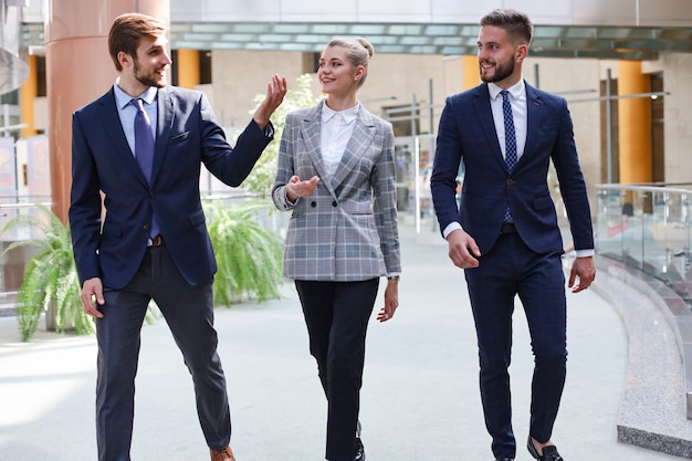 Gruppo di persone di affari che cammina all'interno luminoso moderno dell'ufficio.