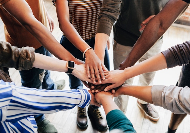 Gruppo di persone diverse che impilano le mani nel mezzo