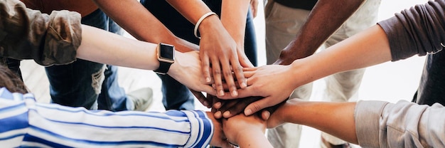 Gruppo di persone diverse che impilano le mani nel mezzo