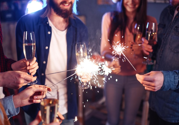 Gruppo di persone felici che tengono le stelle filanti alla festa e sorridenti Persone che celebrano il nuovo anno