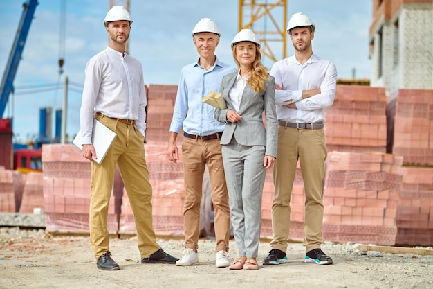 Gruppo di persone in caschi protettivi al cantiere