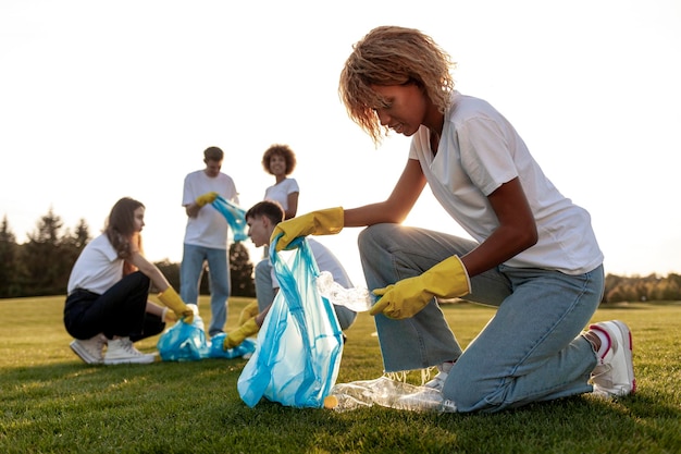 gruppo di persone multirazziali in guanti e con sacchetti della spazzatura rimuovere la plastica e la spazzatura