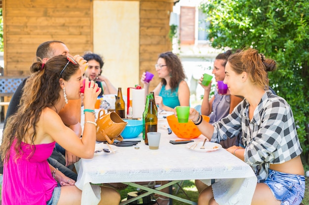 Gruppo di persone sedute a pranzo insieme e a bere