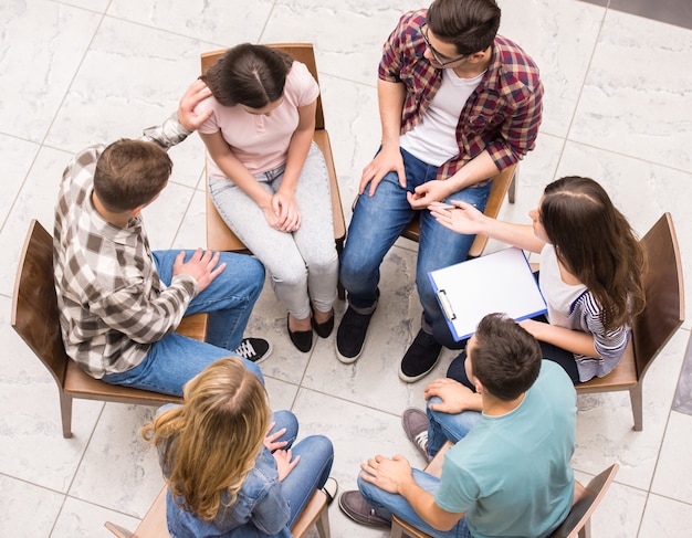 Gruppo di persone sedute vicine le une alle altre.