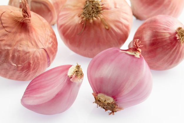 Gruppo di piccolo scalogno rosso su sfondo bianco