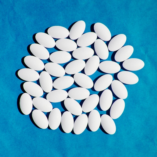 Gruppo di pillole bianche vitamina sulla superficie blu