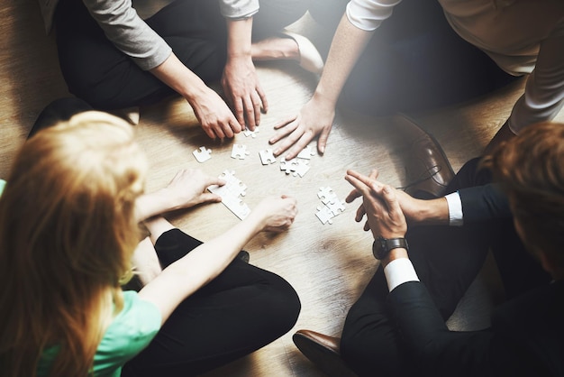 Gruppo di puzzle e persone che pensano al lavoro di squadra e alla collaborazione di soluzioni o al flusso di lavoro nella risoluzione dei problemi e nella sfida Sviluppo di progetti di giochi di team building e brainstorming di donne o uomini in cerchio