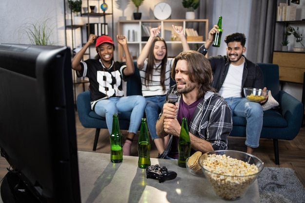 Gruppo di quattro persone multiculturali che cantano karaoke a casa