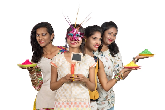Gruppo di ragazze giovani felici divertendosi con polvere colorata a Holi festival dei colori