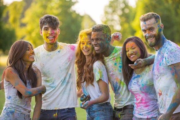 Gruppo di ragazzi che giocano con i colori al festival di holi, in un parco