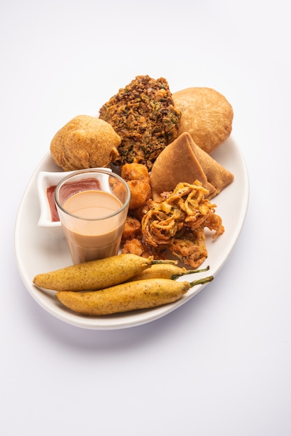 Gruppo di snack indiani per l'ora del tè samosa, kachori, aloo bonda, onion pakora, moong vada, frittella di peperoncino ecc