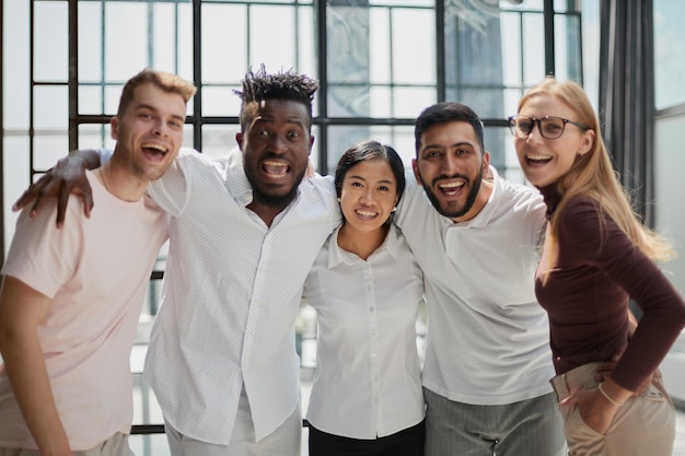 Gruppo di squadra forte e creativo di uomini d'affari e sorridere alla telecamera