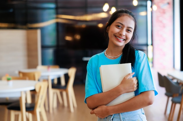 Gruppo di studenti adolescenti che camminano per appoggiarsi nella biblioteca della scuola Istruzione della biblioteca universitaria e concetto di apprendimento degli studenti