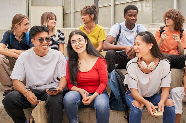 Gruppo di studenti multietnici che guardano felicemente la telecamera durante una pausa