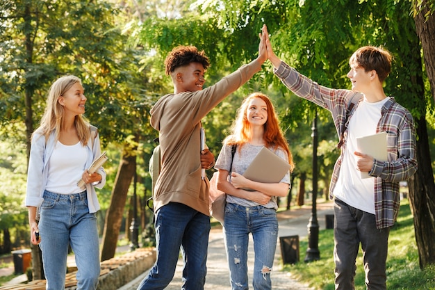 Gruppo di studenti ridenti che camminano al campus