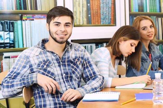 Gruppo di studenti seduti a tavola in biblioteca