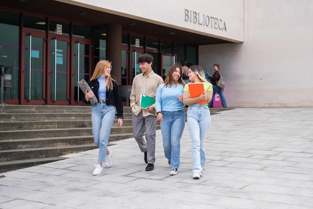 Gruppo di studenti universitari che lasciano la biblioteca per studiare