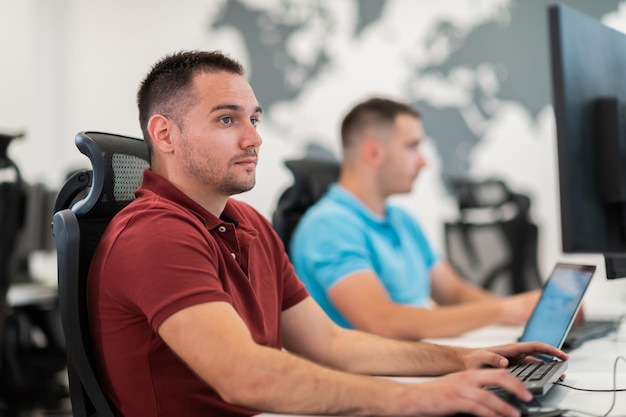 Gruppo di uomini d'affari casual che lavorano su un computer desktop nell'interno moderno dell'ufficio di avvio del piano aperto. Messa a fuoco selettiva. Foto di alta qualità