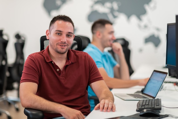 Gruppo di uomini d'affari casual che lavorano su un computer desktop nell'interno moderno dell'ufficio di avvio del piano aperto. Messa a fuoco selettiva. Foto di alta qualità