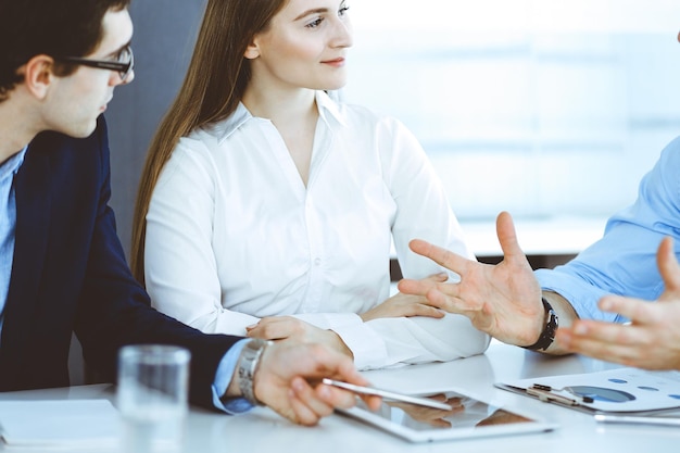 Gruppo di uomini d'affari che discutono di domande durante la riunione in un ufficio moderno. Manager in trattativa o brainstorming. Concetto di lavoro di squadra, partnership e business