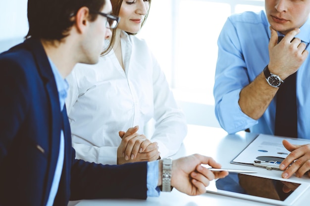 Gruppo di uomini d'affari che discutono di domande durante la riunione in un ufficio moderno. Manager in trattativa o brainstorming. Concetto di lavoro di squadra, partnership e business