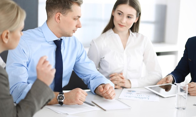 Gruppo di uomini d'affari che discutono questioni in una riunione in un ufficio moderno. Gestori in negoziazione o brainstorming. Lavoro di squadra, partnership e concetto di business