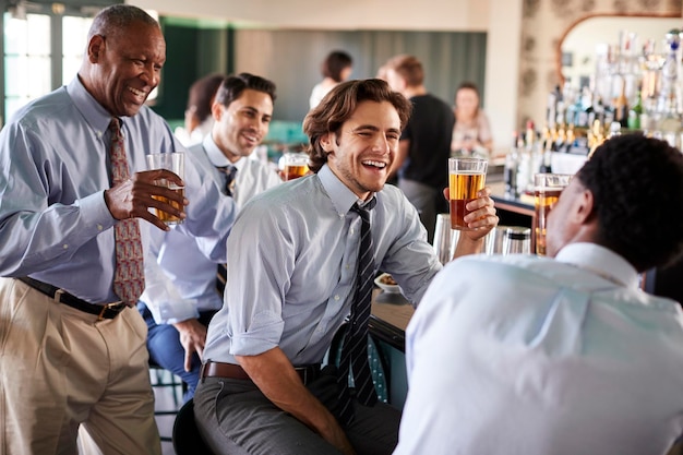 Gruppo di uomini d'affari che si incontrano per un drink dopo i lavori nel bar