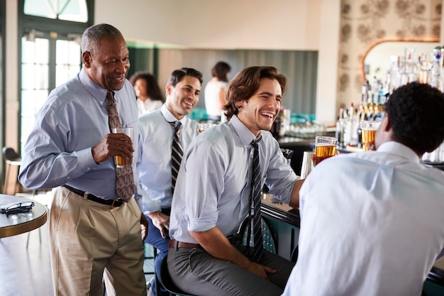 Gruppo di uomini d'affari che si incontrano per un drink dopo i lavori nel bar