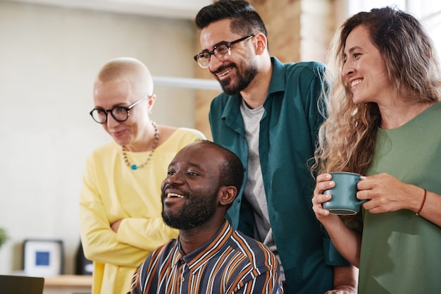 Gruppo di uomini d'affari di successo che sorridono e ridono mentre lavorano insieme in squadra