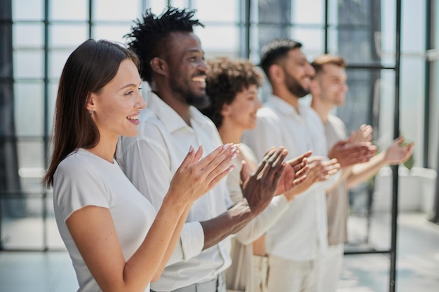 Gruppo di uomini d'affari seduti in fila e che applaudono