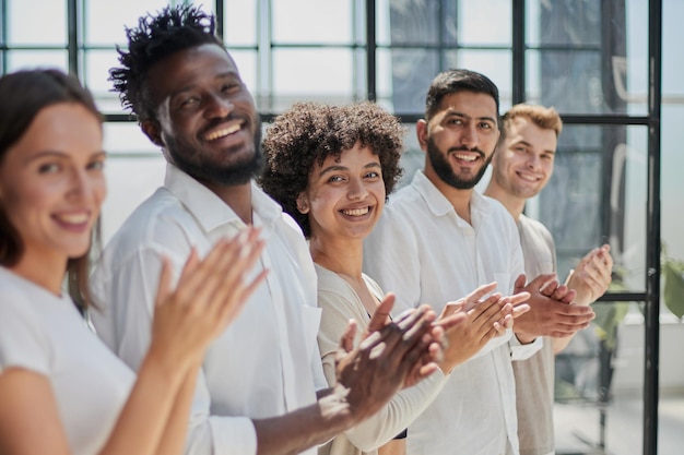 Gruppo di uomini d'affari seduti in fila e che applaudono