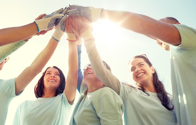 gruppo di volontari che fanno il high five all'aperto