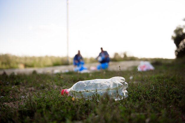 Gruppo eterogeneo di persone che raccolgono rifiuti nel servizio comunitario di volontariato del parco.