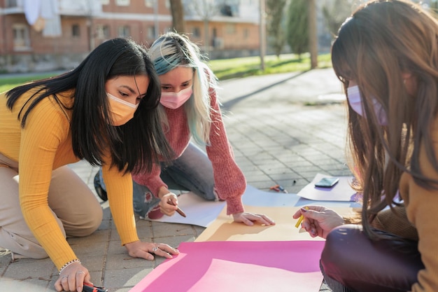 Gruppo multiculturale che prepara insieme la giornata internazionale delle donne del movimento femminista m