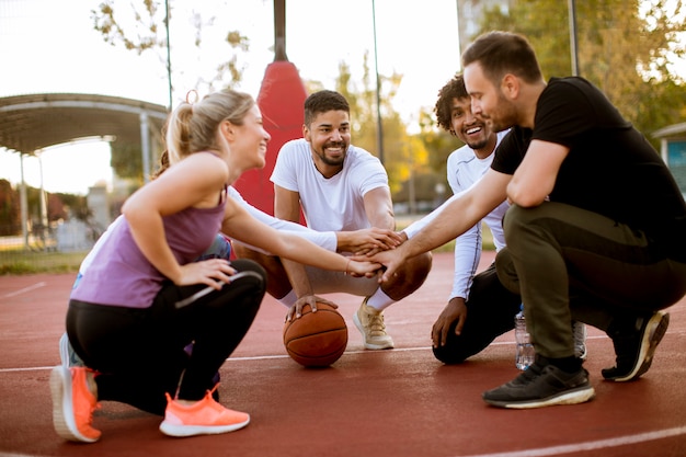 Gruppo multietnico di giocatori di pallacanestro che riposa sulla corte