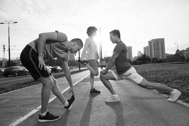 gruppo multietnico di giovani sulla bella mattinata da jogging mentre il sole sorge per le strade della città