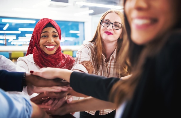 Gruppo multietnico di giovani uomini d'affari che celebrano il successo nei loro luoghi di lavoro nel successo dell'ufficio di avvio e concetto vincente