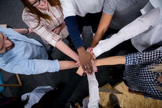 Gruppo multietnico di giovani uomini d'affari che celebrano il successo nei loro luoghi di lavoro nel successo dell'ufficio di avvio e concetto vincente